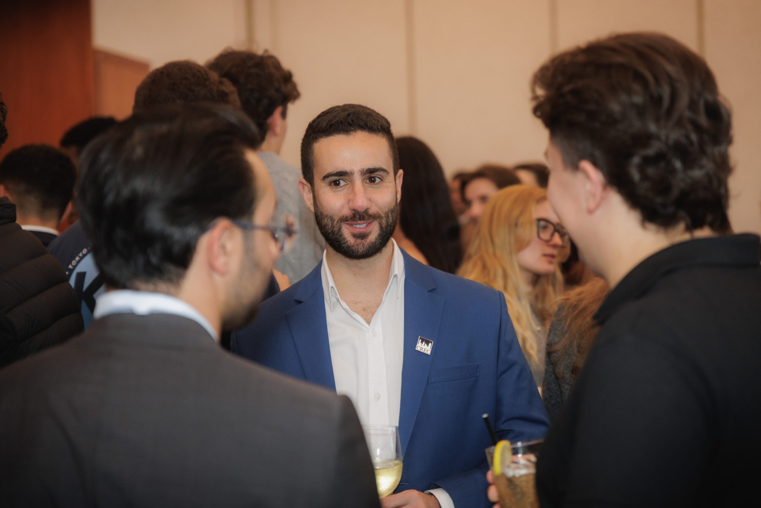 Students and real estate professionals engaged in conversation at a networking event, fostering connections and industry insights.